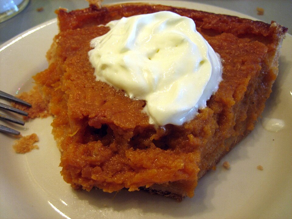 A sweet potato pie with a slice removed
